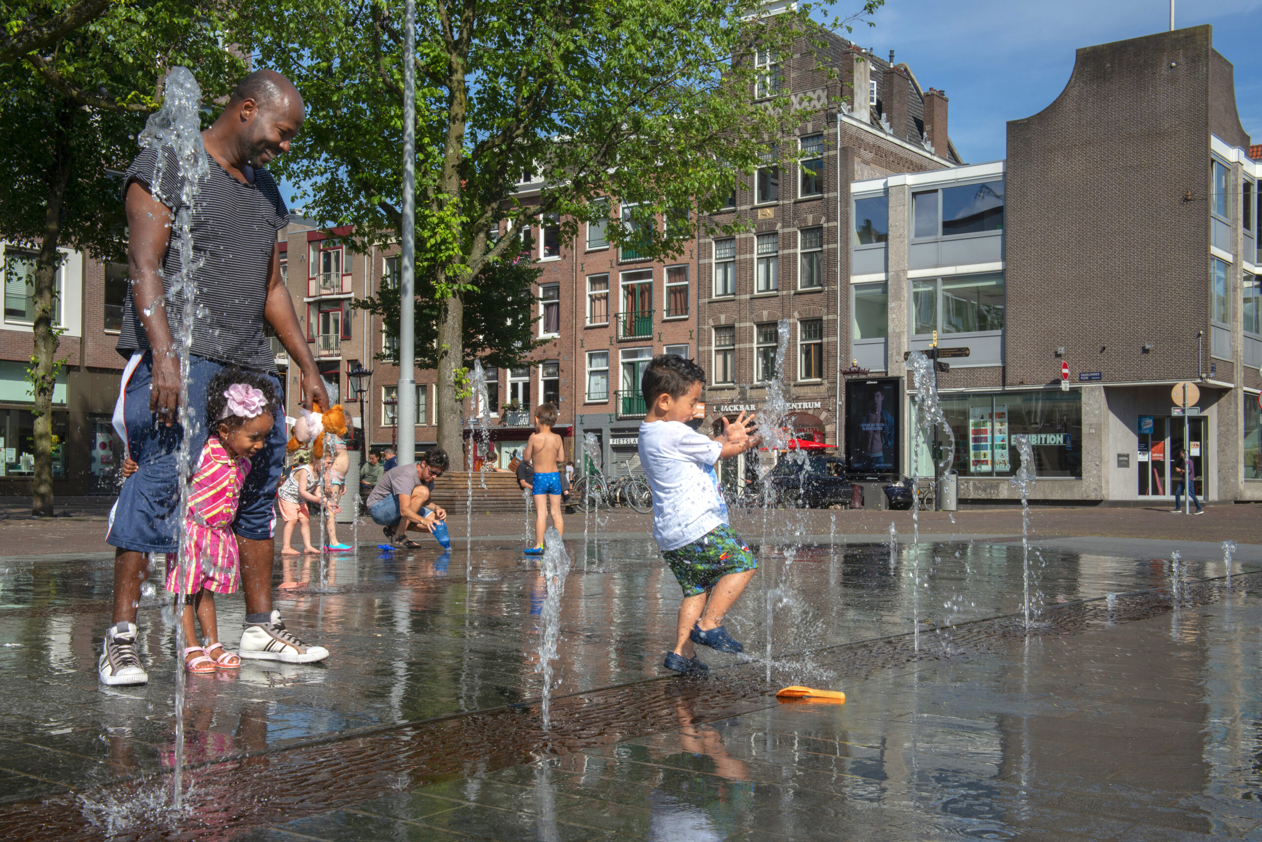 Plein met spelende kinderen in een fontijn