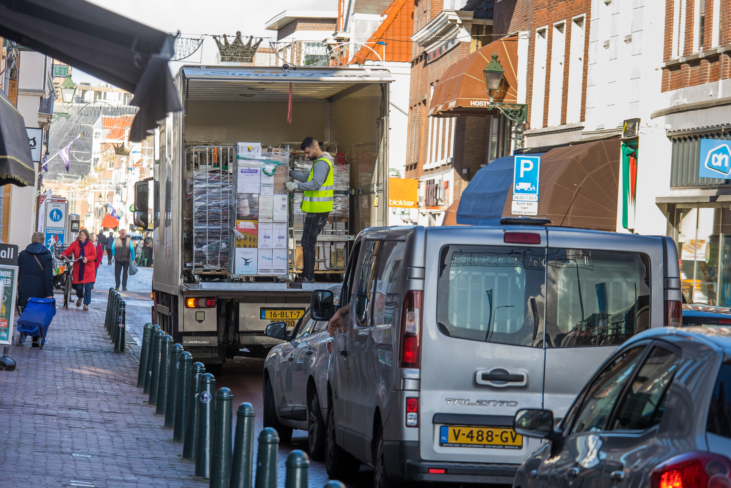 Foto van een truck die aan het laden en lossen is in een drukke straat in de stad