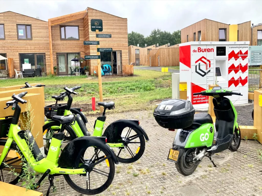 Foto van een hub met deelfietsen en brommer in nieuwe woonwijk