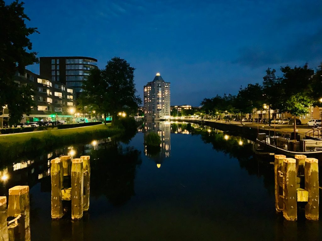 body of water near high rise buildings during night time