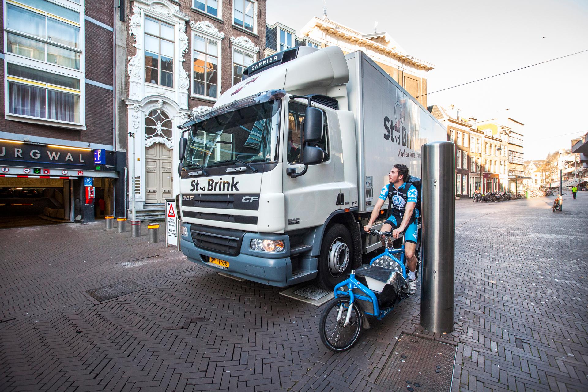 Fietskoerier in Den Haag, Nederland, Zuid-Holland, Den Haag, november 2014. Een fietskoerier fietst op zijn vrachtfiets door het centrum van Den Haag. Foto: Bart van Vliet